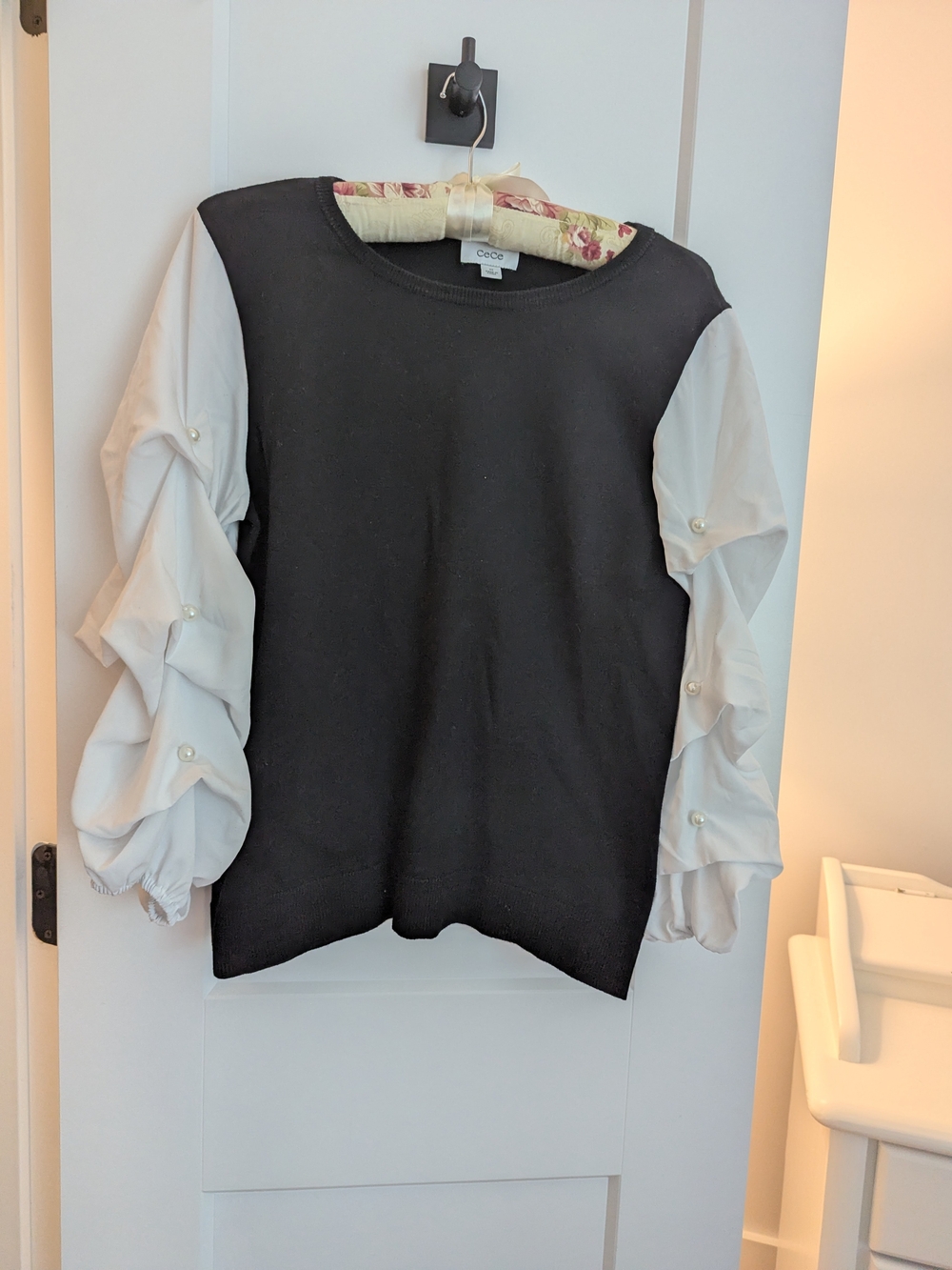 CeCe Black Knit Top with White Pearl-Button Ruffle Sleeves